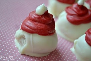 White Chocolate Raspberry Oreo Truffles are flavored with raspberry extract and decorated to look like adorable little Santa hats!