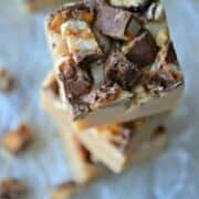 White Chocolate Peanut Butter Snickers Fudge will be the hit of your holiday party! These creamy fudge morsels take 5 minutes or less to make, and 2 seconds to eat! Simply delicious and a perfect sweet treat.