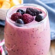 mango-berry smoothie in a glass garnished with fresh berries