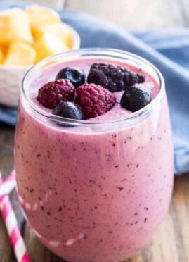 mango-berry smoothie in a glass garnished with fresh berries