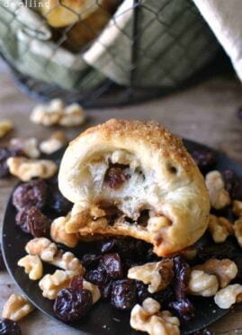 Cranberry Walnut Knots made with Rhodes Dinner Rolls are easy to make and are sure to please everyone. These delicious little rolls are stuffed with dried cranberries and walnuts and topped with a brown sugar streusel to add a little sweetness to your Thanksgiving table!