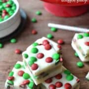M&M Cookie Dough Stuffed Fudge is an easy, delicious recipe thats perfect for the holidays. This 5 minute fudge is made with white chocolate stuffed with an M&M cookie dough and topped with more M&M's! A crowd pleaser and a great gift!