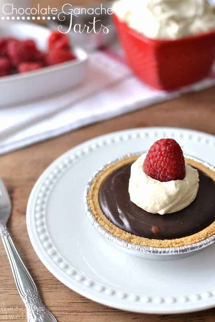 These Chocolate Ganache Tarts are topped with fresh orange whipped cream and raspberries.