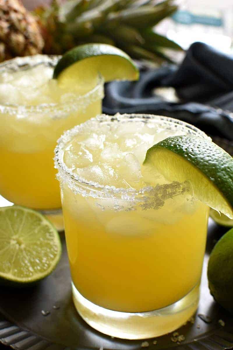 disse ananas Margaritas er en lækker sød, forfriskende vri på originalen! Lavet med kun 4 enkle ingredienser og perfekt til happy hour, fridage og hele sommeren!