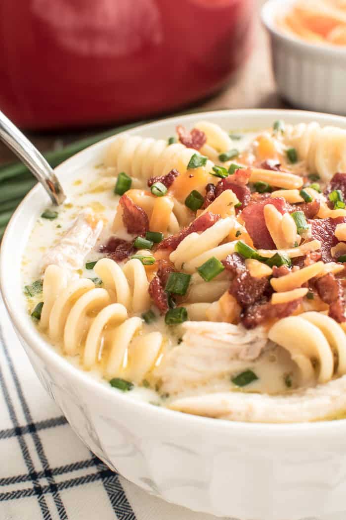 Qui n'aime pas la soupe de nouilles au poulet maison....surtout quand ça monte d'un cran !? Cette soupe de nouilles au poulet Ranch au Cheddar au bacon porte la recette classique à un nouveau niveau avec l'ajout de fromage cheddar, d'assaisonnement ranch, de ciboulette et...bien sûr...bacon! Parfaite pour les mois froids de l'hiver et tout aussi délicieuse toute l'année, si vous aimez une bonne soupe crémeuse de nouilles au poulet, vous adorerez cette recette!'t love homemade chicken noodle soup....especially when it's kicked up a notch!? This Bacon Cheddar Ranch Chicken Noodle Soup takes the classic recipe to a new level with the addition of cheddar cheese, ranch seasoning, chives, and...of course...bacon! Perfect for the cold months of winter and equally delicious all year round, if you love a good creamy chicken noodle soup, you'll love this recipe! 