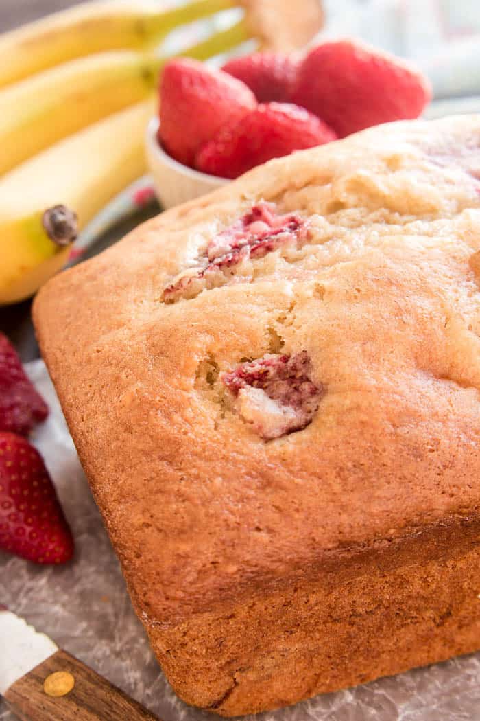 Banana Bread gets a fun new twist with the addition of fresh strawberries! This Strawberry Banana Bread starts with the BEST Banana Bread recipe and adds just a few simple ingredients to take it to the next level. Perfect for breakfast, snack, or even dessert...this recipe is packed with delicious flavor and sure to become a new favorite. If your family loves fresh, homemade bread, they'll go crazy for this delicious Strawberry Banana Bread! And you'll love how easy it is to make!