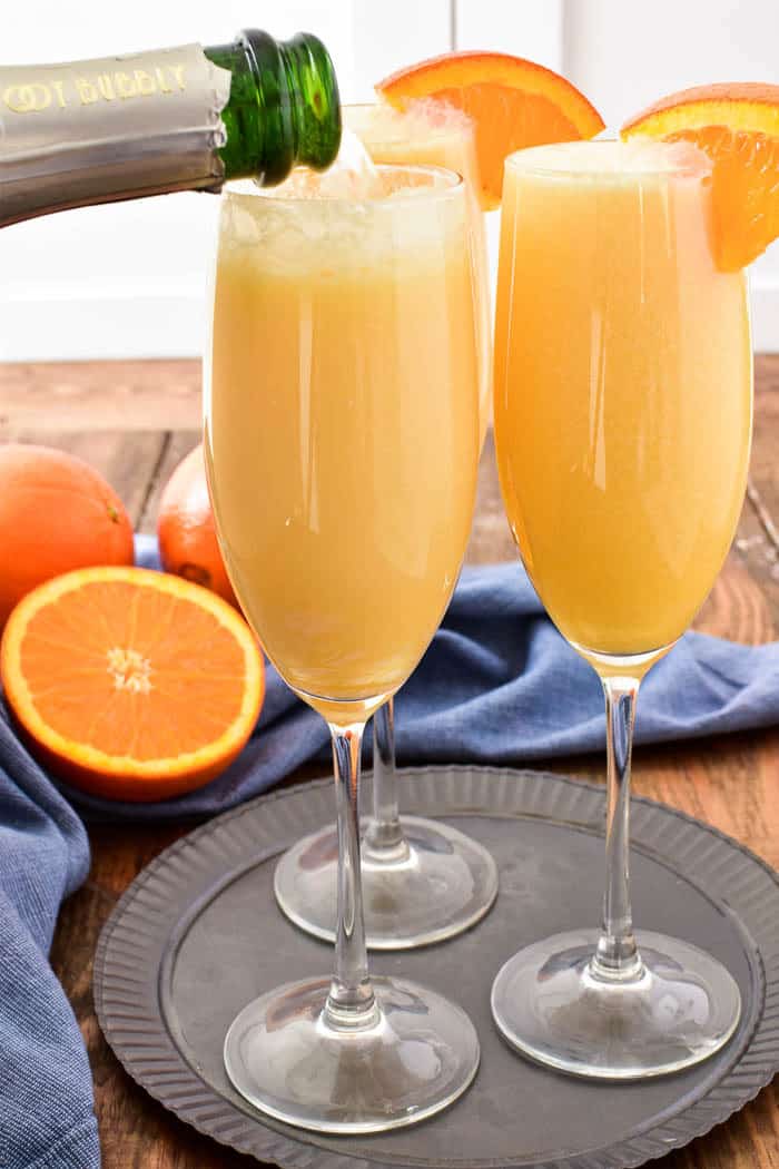 Take your favorite breakfast cocktail to the next level with these delicious Orange Creamsicle Mimosas! They combine the fun of childhood with the deliciousness of adulthood....all in one glass. Made with 4 simple ingredients, these mimosas are just the right blend of creamy, sweet, and bubbly. Perfect for weekend brunches, ladies' nights, or lazy days by the pool. If you love mimosas (and who doesn't!?) you'll love this fun, creamy, YUMMY twist!