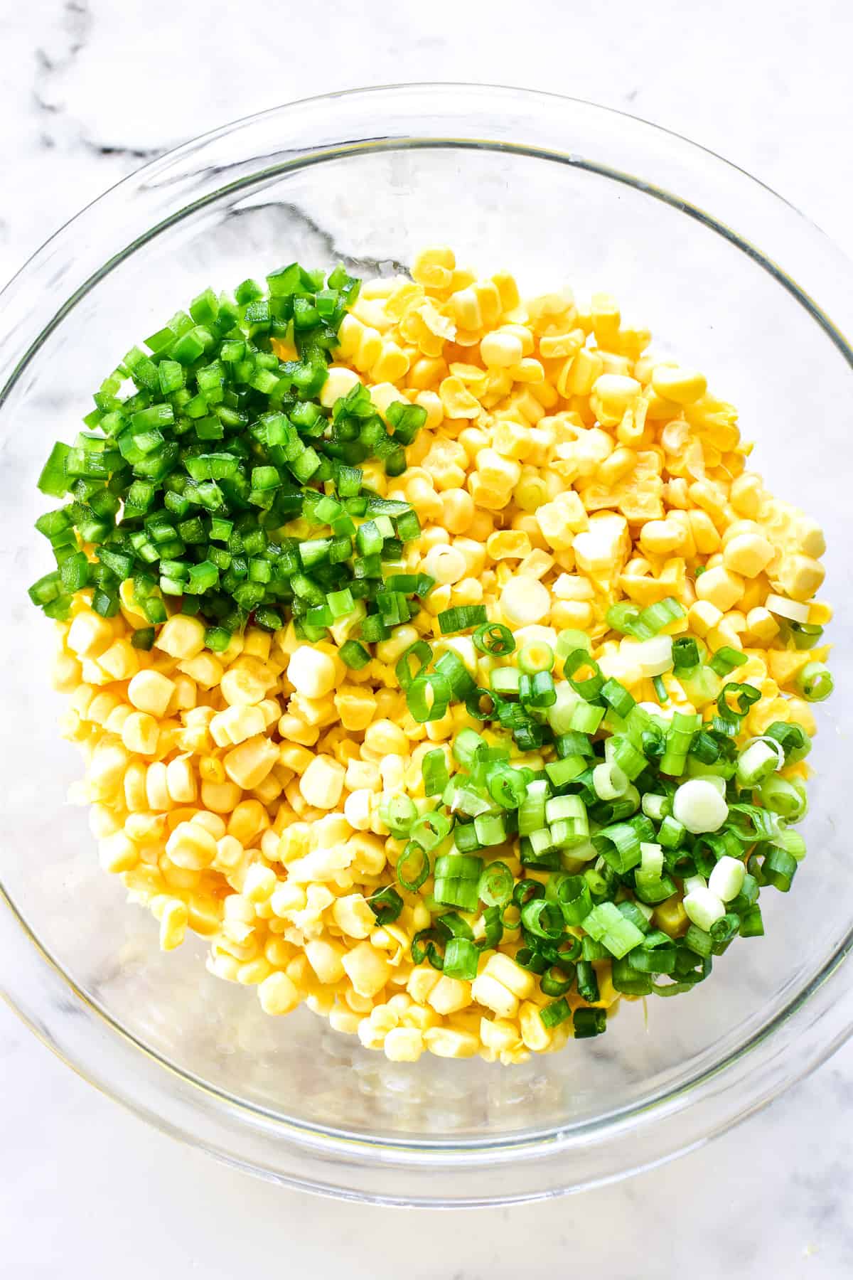 Fresh corn, minced jalapenos, and slice green onions in a mixing bowl