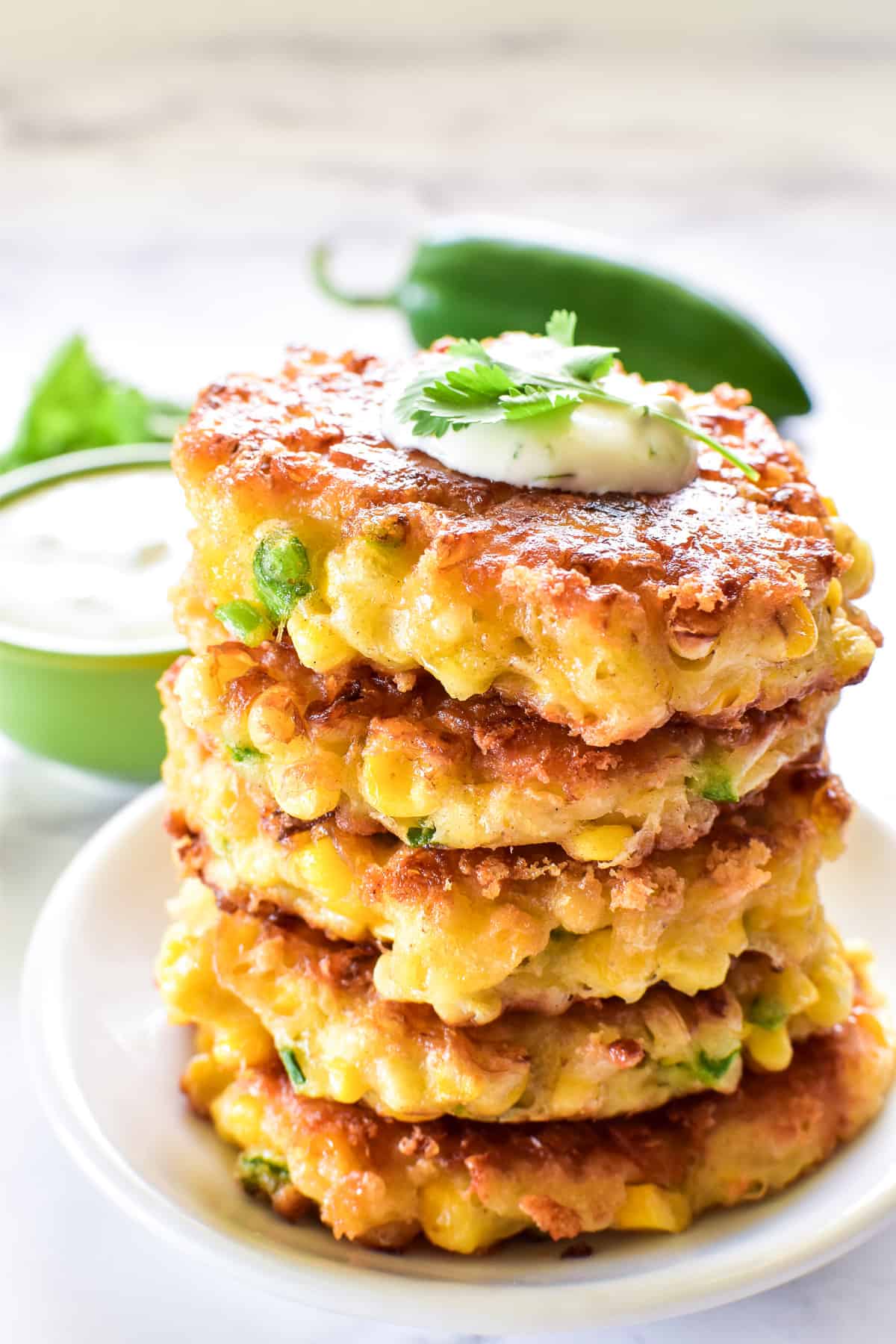 Corn Fritters stacked on a small white plate