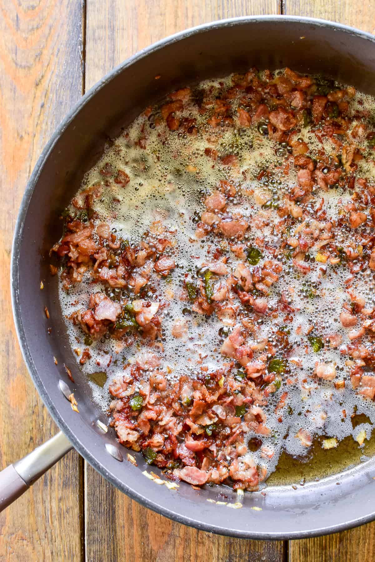 Bacon, leeks, and Poblano peppers frying in a skillet