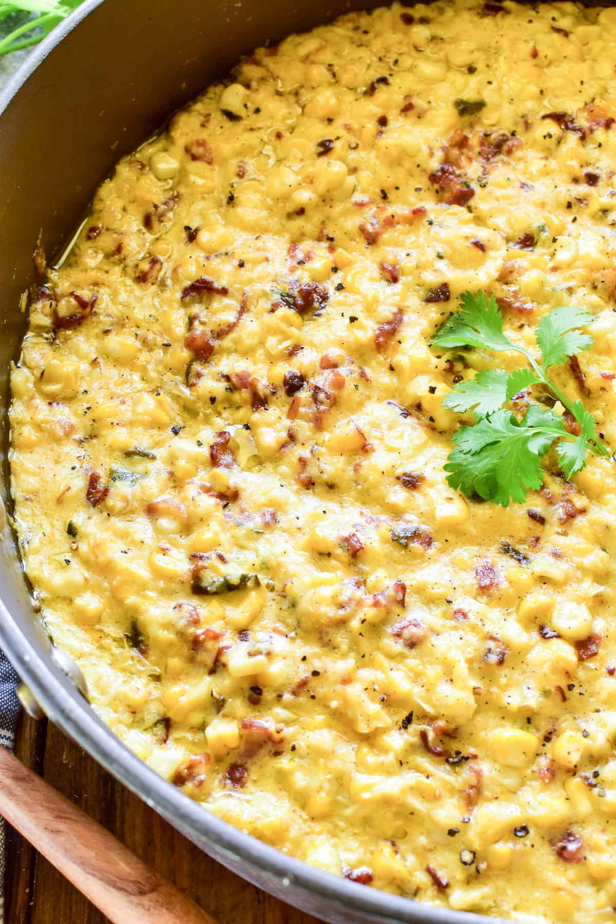 Creamed Corn in a skillet garnished with fresh cilantro