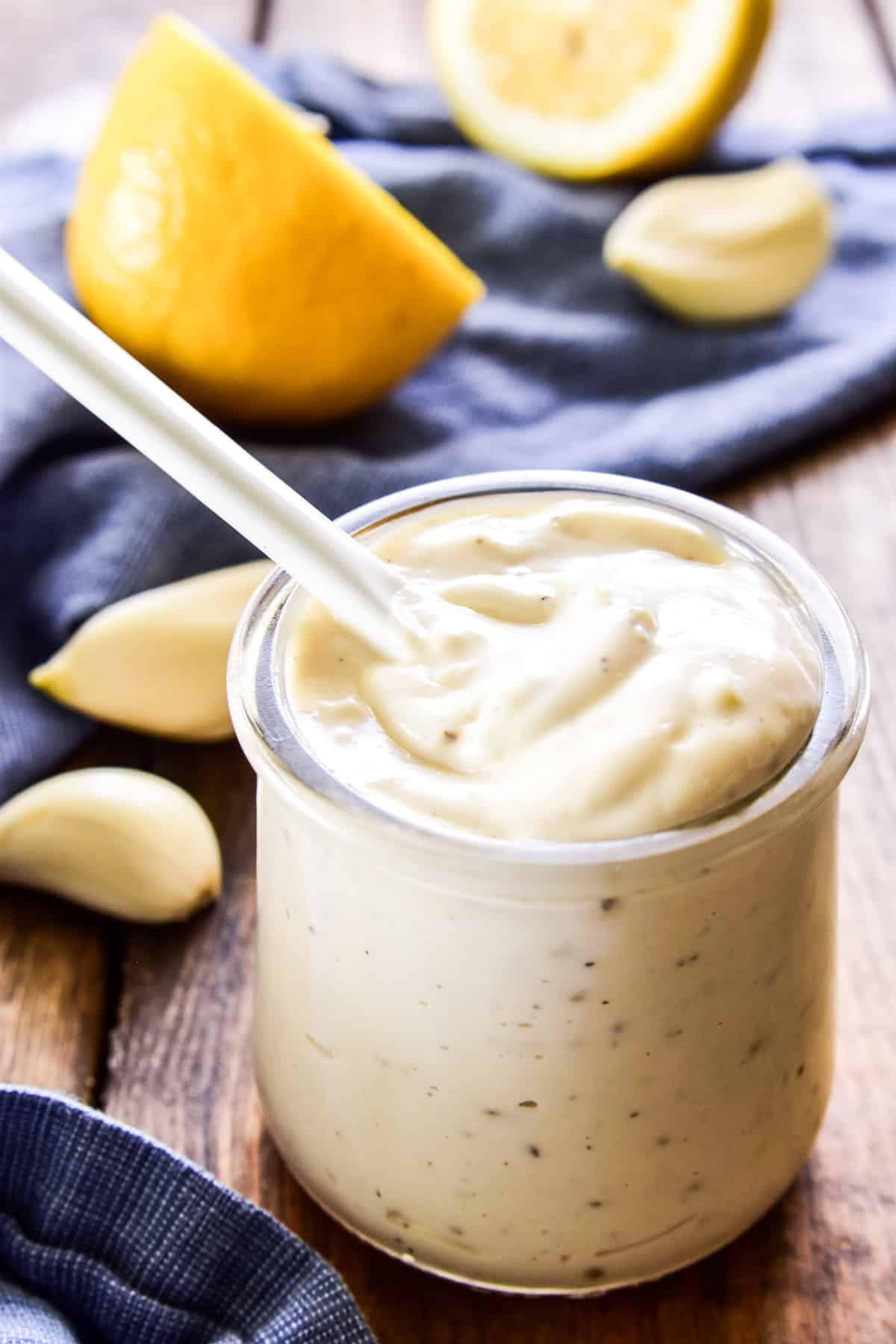 Garlic Aioli in a glass jar with a small white serving spoon