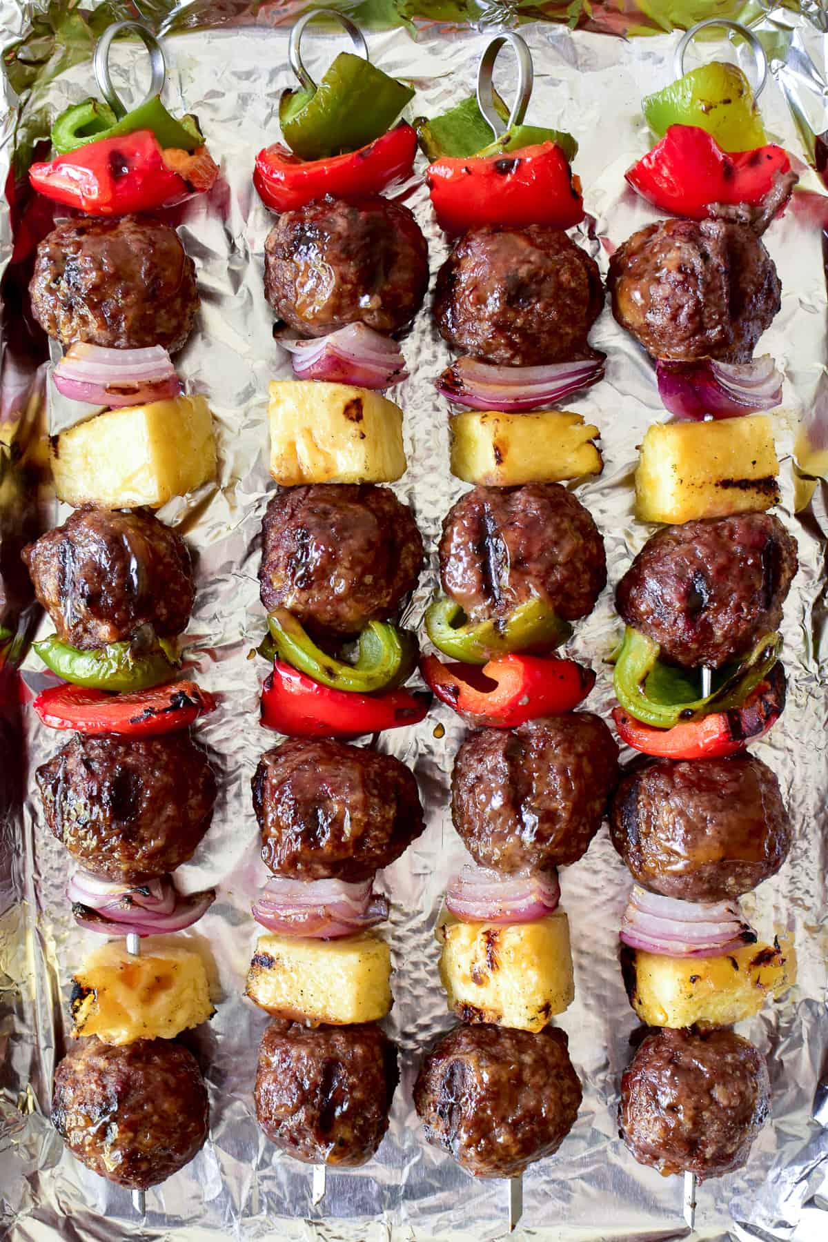 Overhead shot of Hawaiian Meatballs with peppers, onions and pineapple on skewers