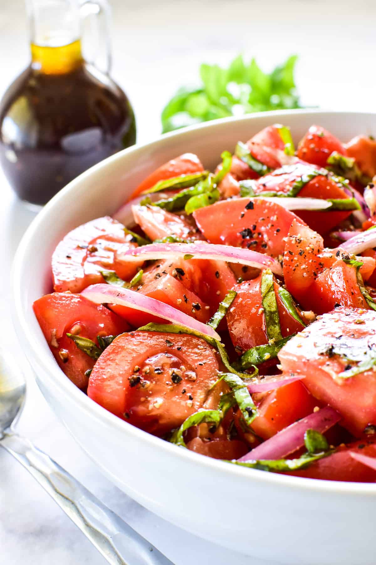 Side shot of Tomato Salad in a bowl with balsamic vinaigrette 