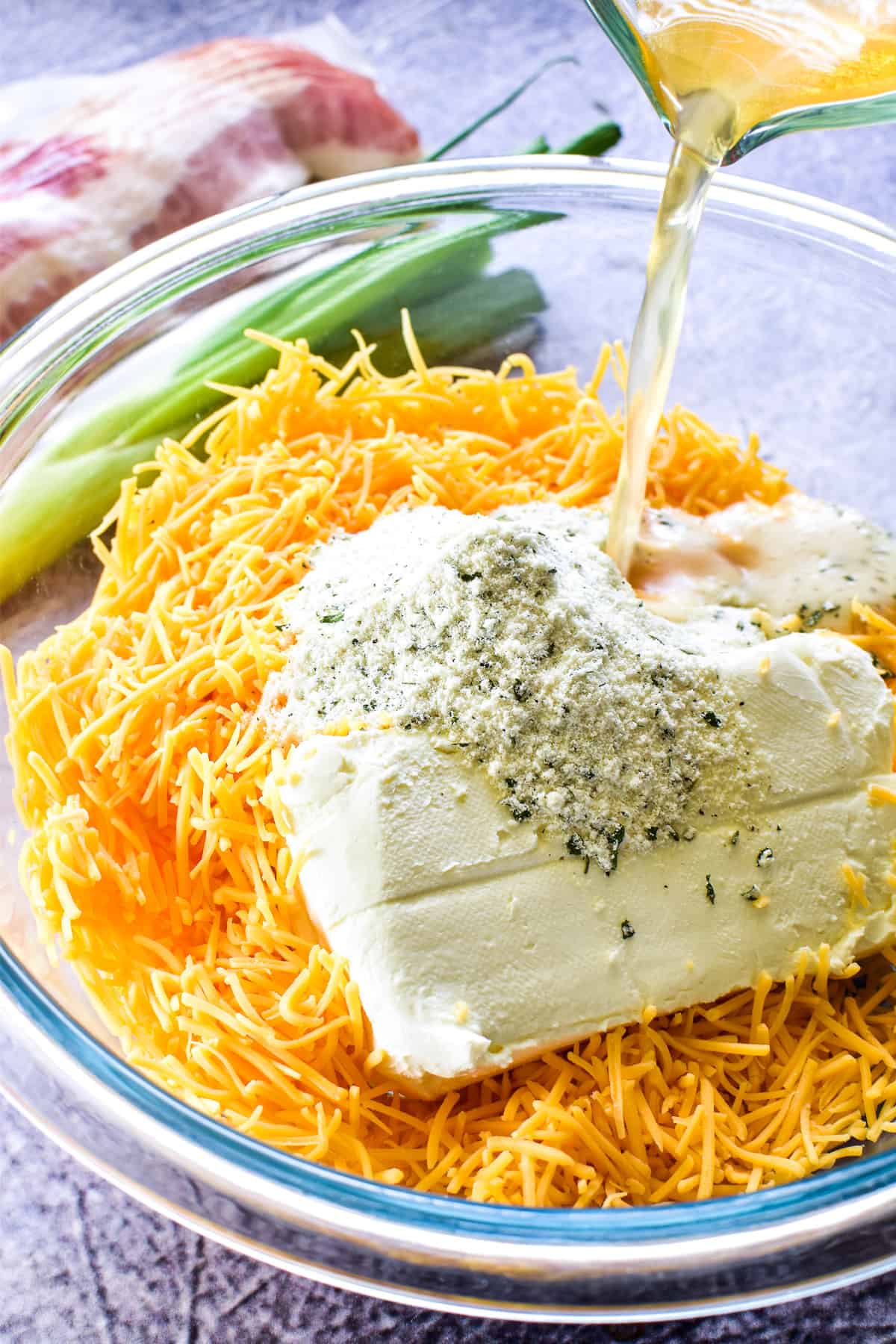 Beer Cheese Dip ingredients in a mixing bowl with a beer pour shot