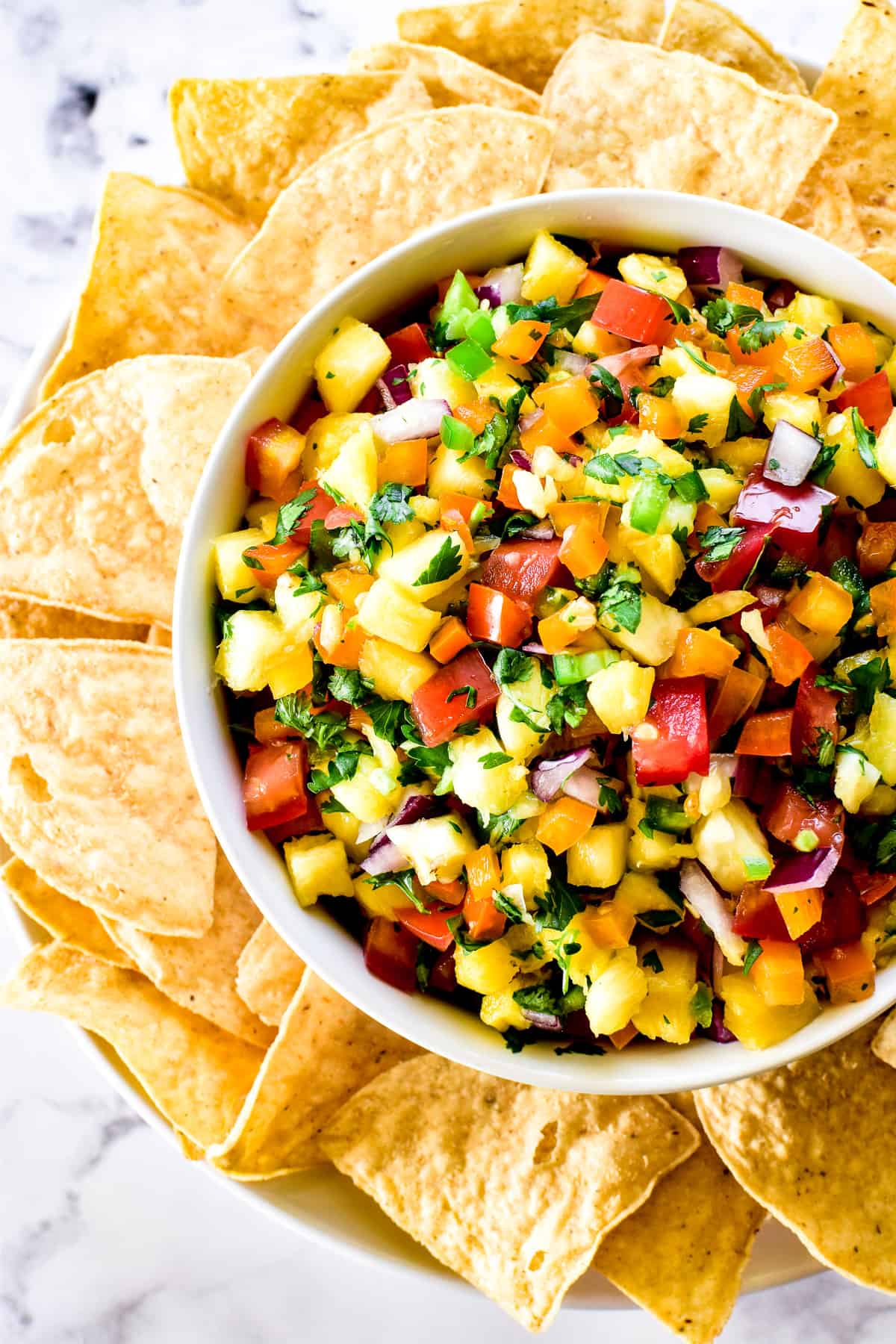 Close up of Pineapple Salsa with tortilla chips on serving plate