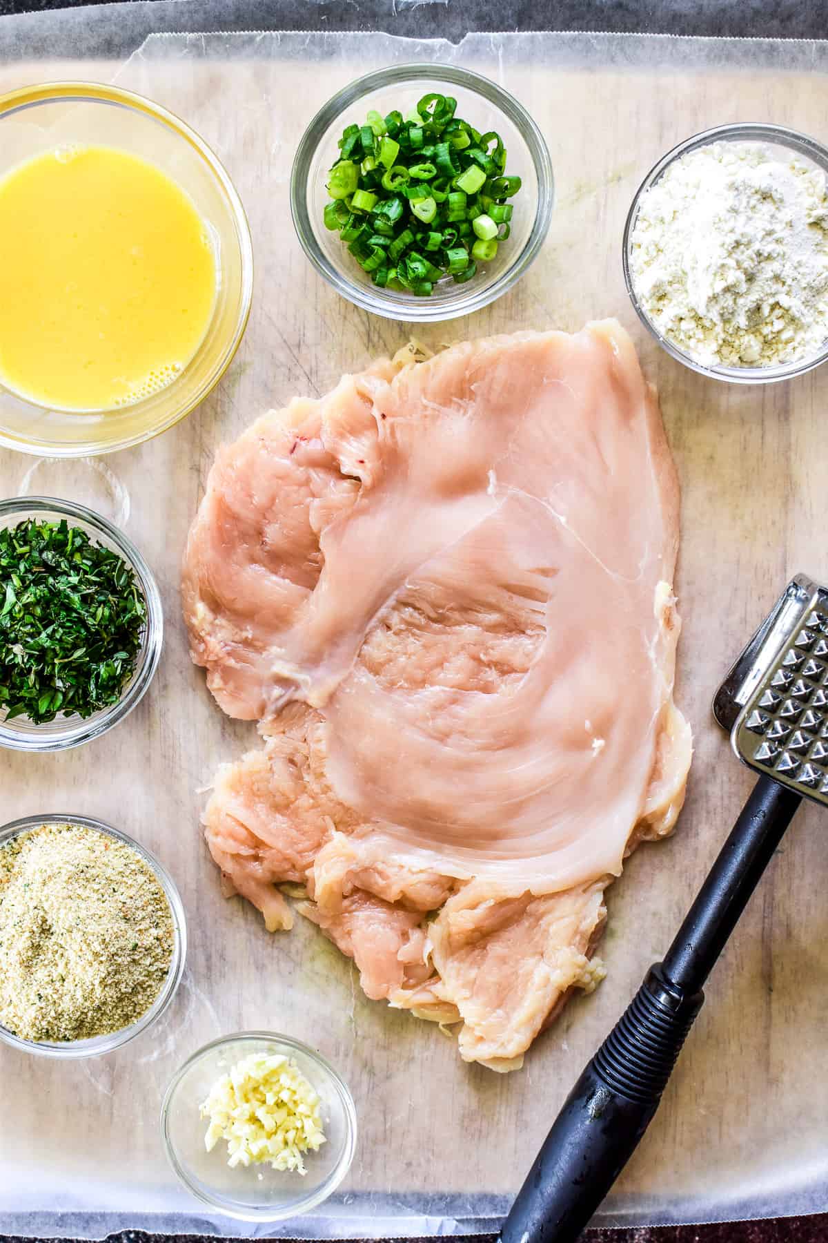 Prep shot of pounded chicken and other Chicken Kiev ingredients