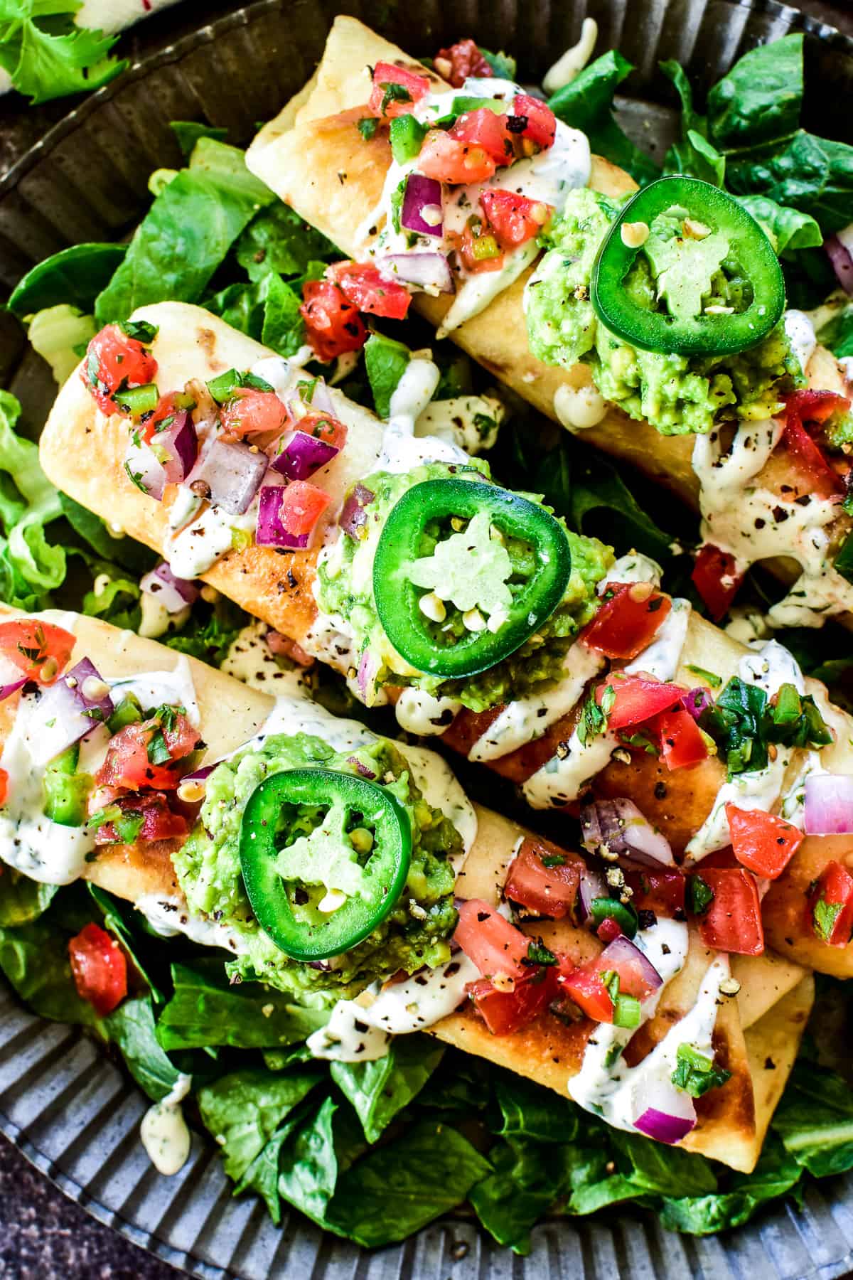 Overhead close up of Creamy Chicken Flautas loaded with toppings