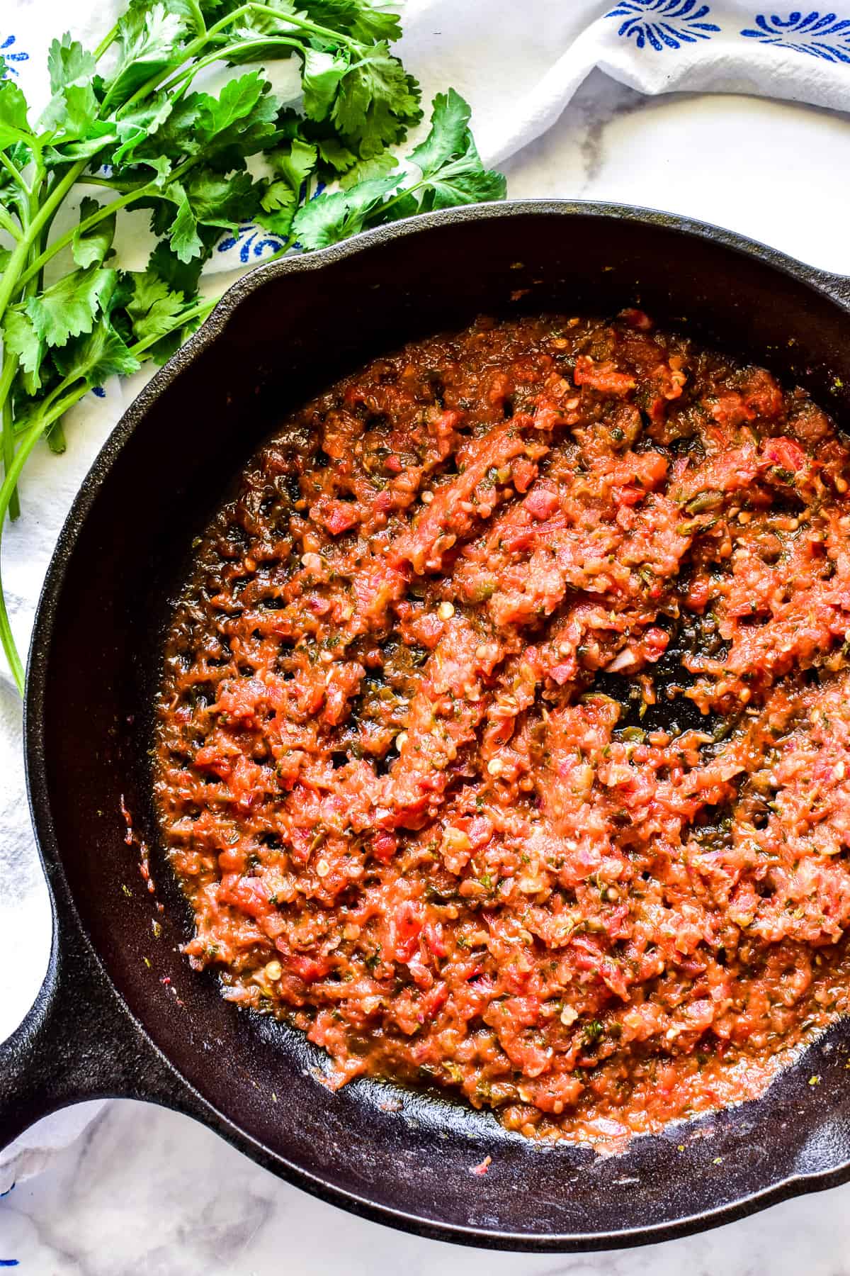 Cooked salsa in a black cast iron skillet