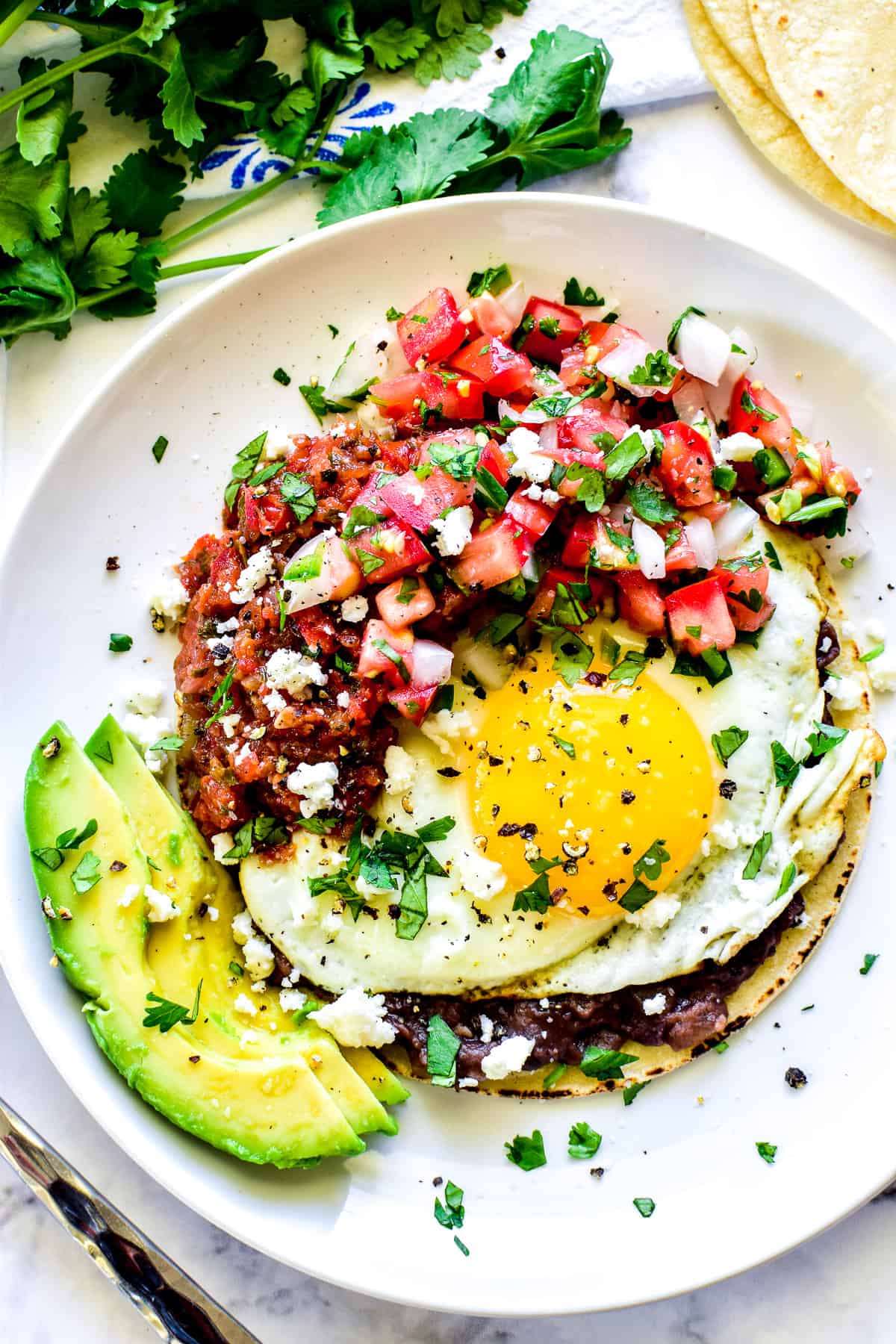 Overhead shot of Huevos Rancheros on a white plate