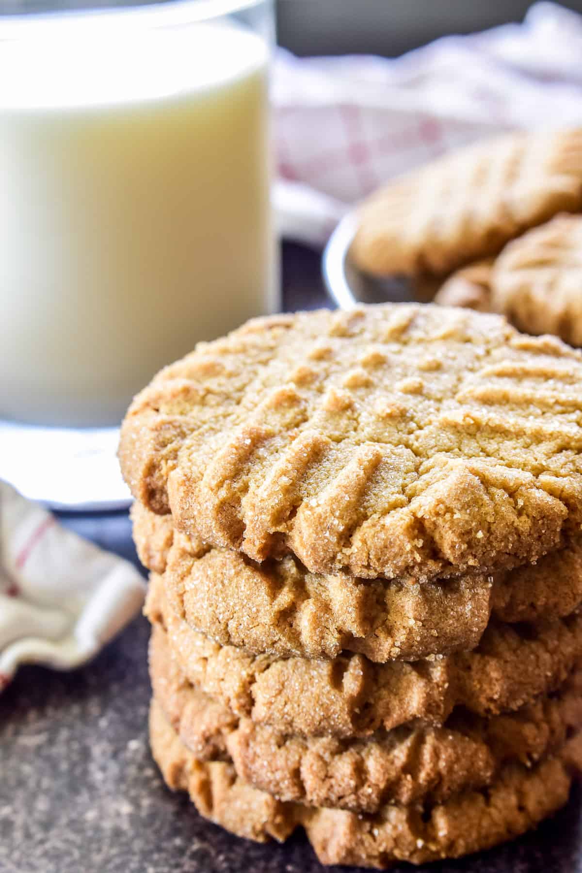 Stack of 5 peanut butter cookies with a glass of milk