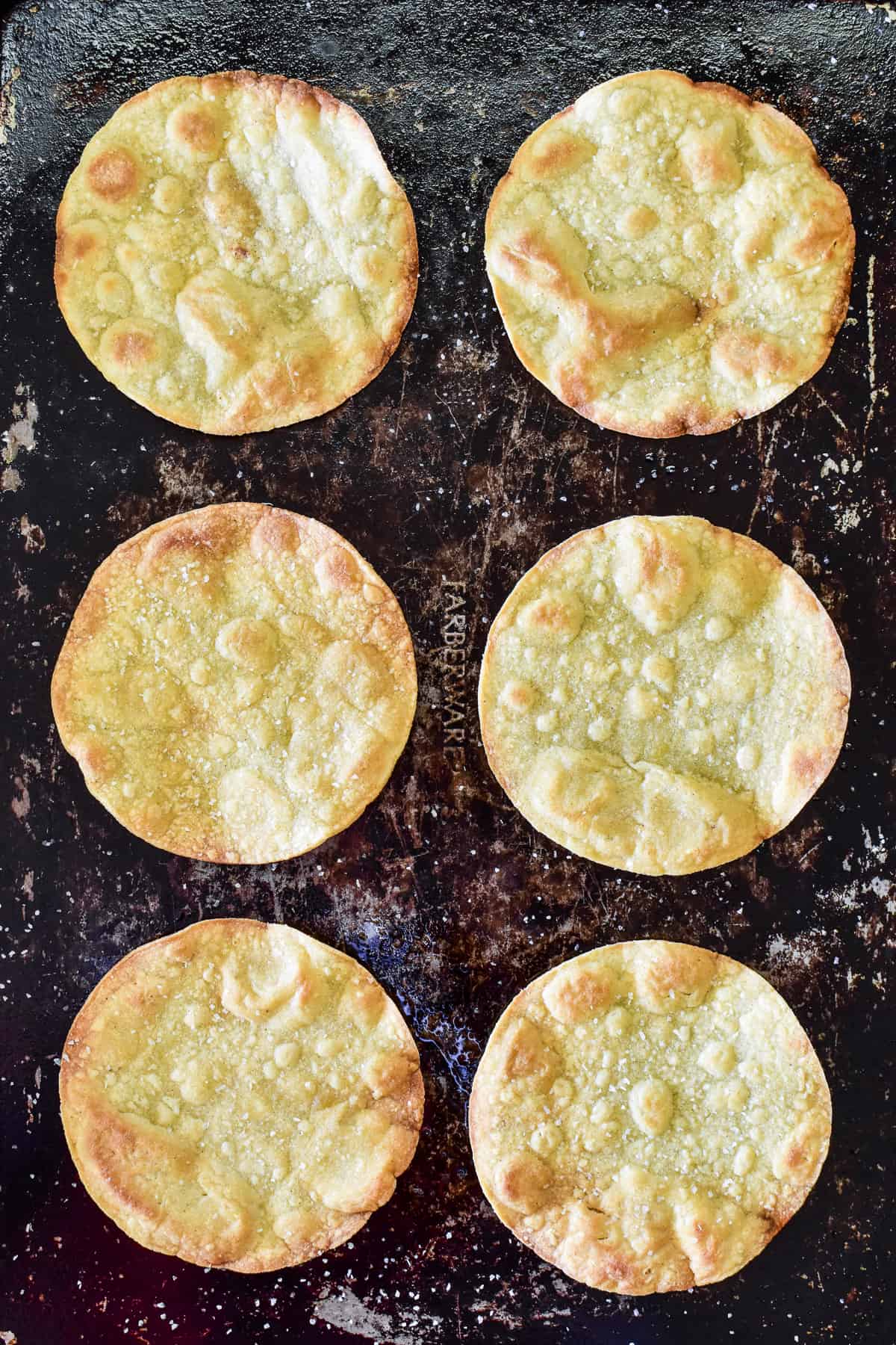 Overhead shot of tostada shells on baking sheet