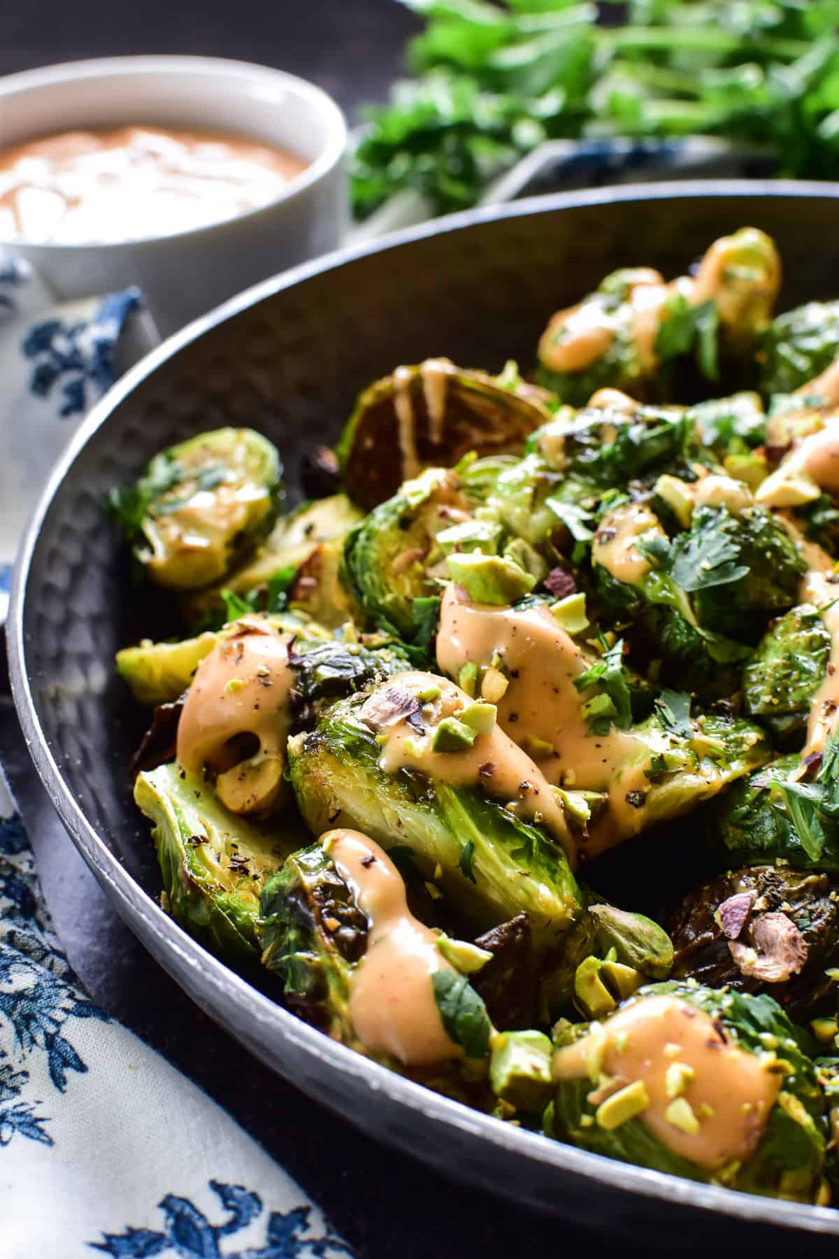 Close up of Air Fryer Brussels Sprouts with sesame sriracha aioli, cashews, and cilantro