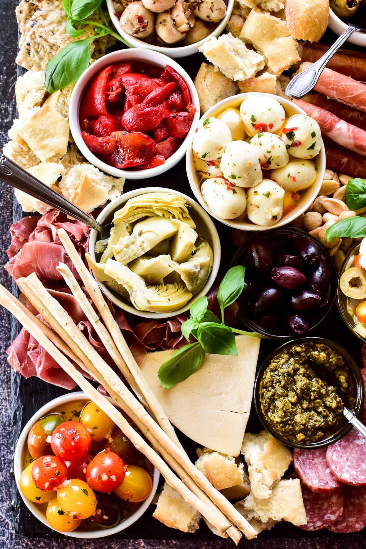 Overhead shot of veggies, meats and cheeses on antipasto platter