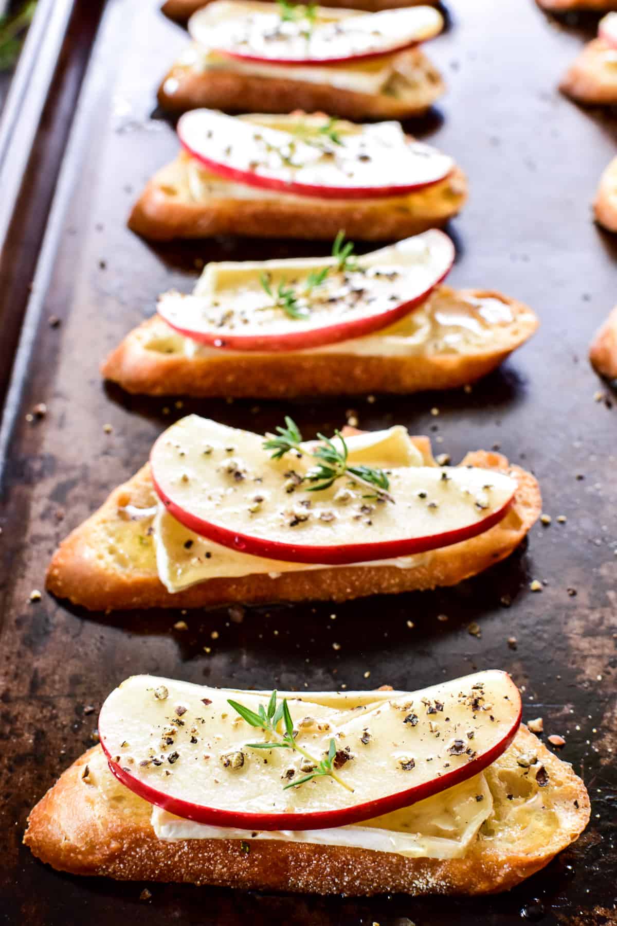 Close up of Apple Brie Crostini in a row on a baking sheet