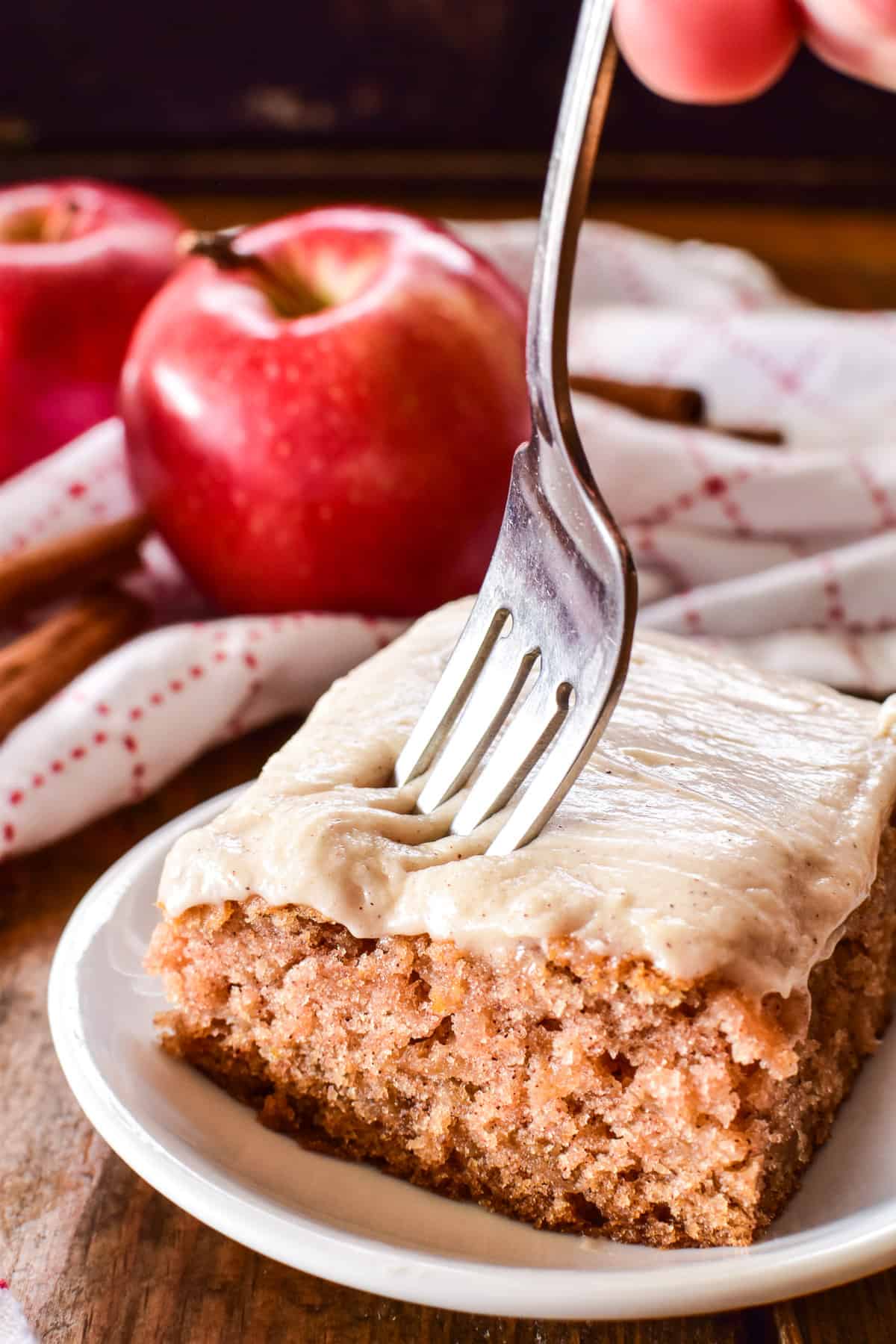 Fork cutting into piece of apple cake