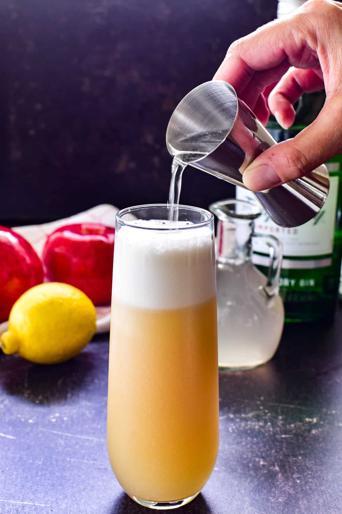 Pour shot adding seltzer to Apple Gin Fizz