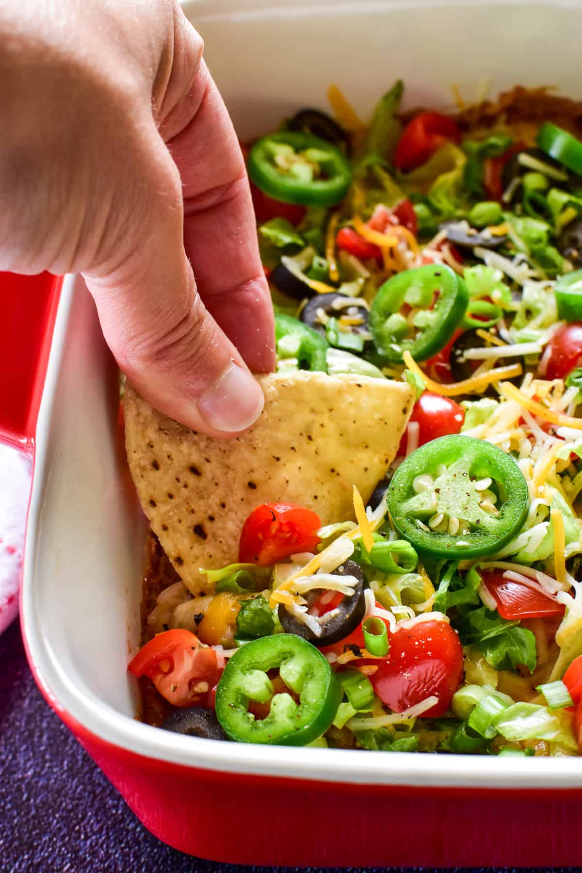 Hand dipping chip into taco dip