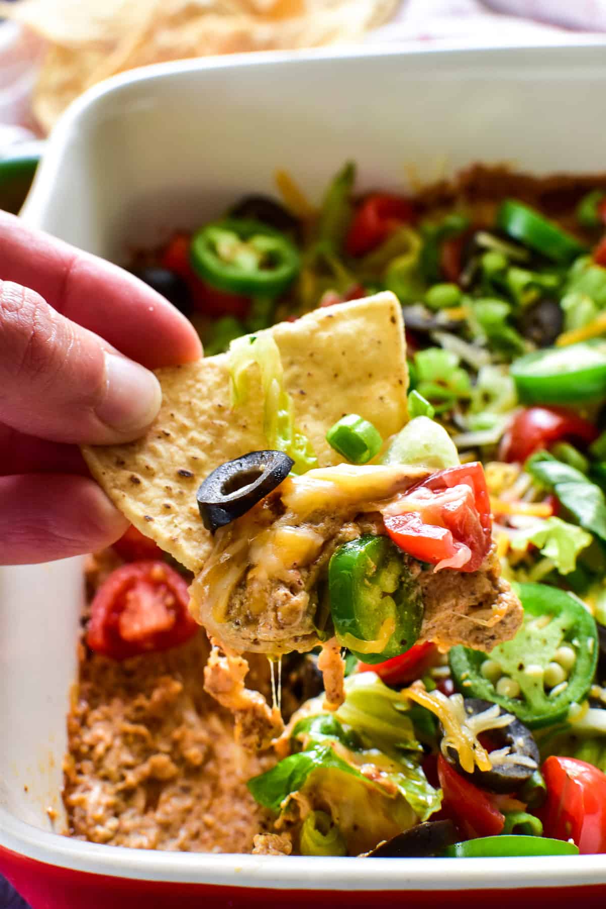 Tortilla chip dipping into Baked Taco Dip