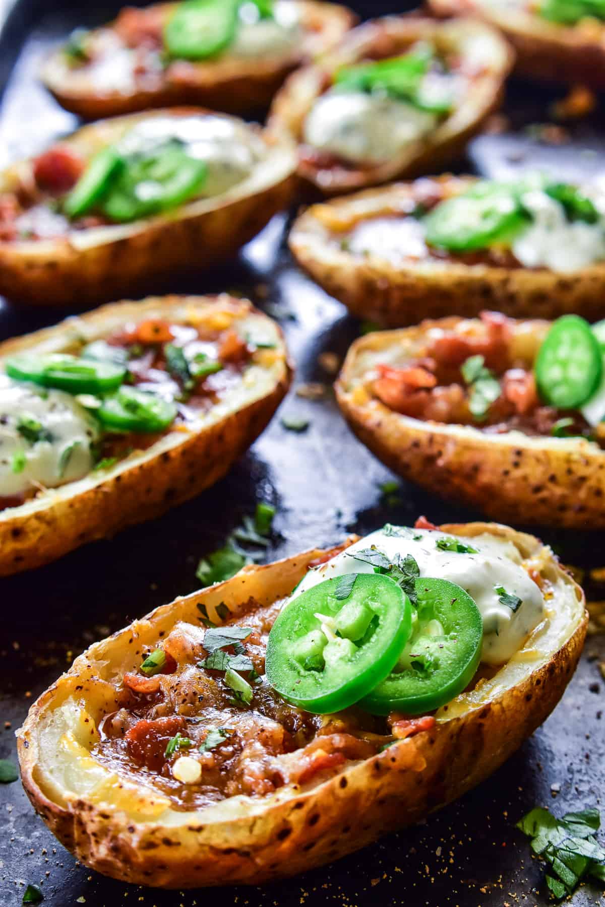 Close up of Loaded Potato Skins with jalapeños and cilantro lime sauce