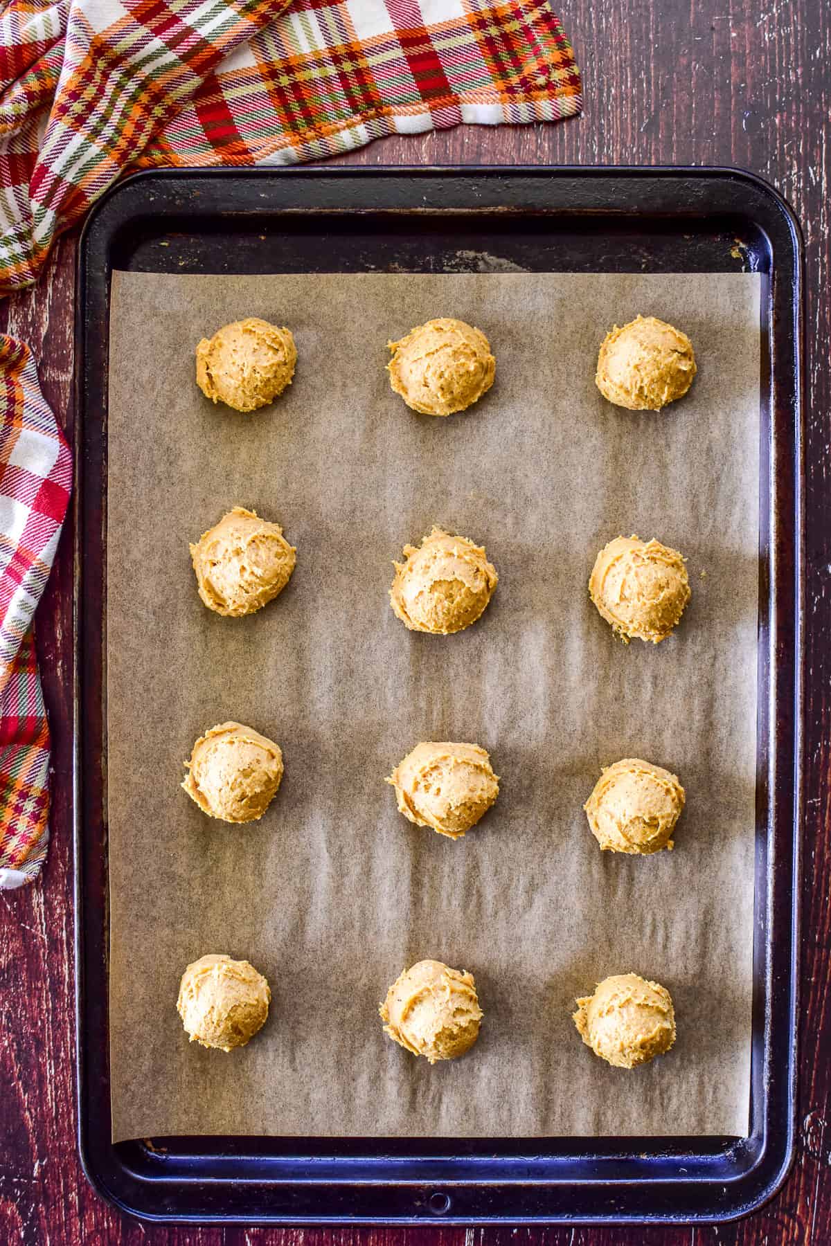 Overhead shot of pumpkin cookie dough scooped onto a baking sheet