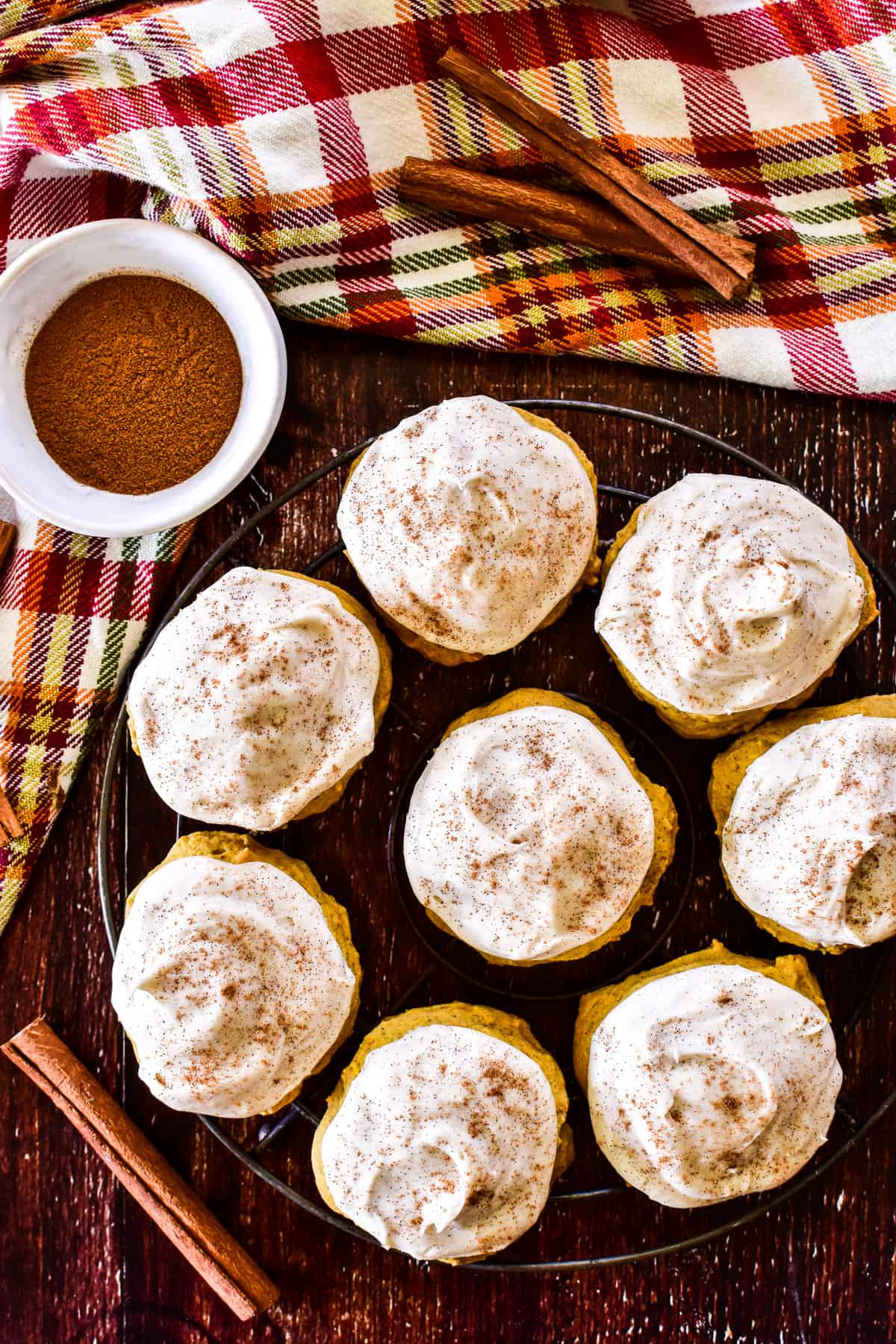 Overhead shot of Pumpkin Cookies with cinnamon sticks and a plaid fall napkin