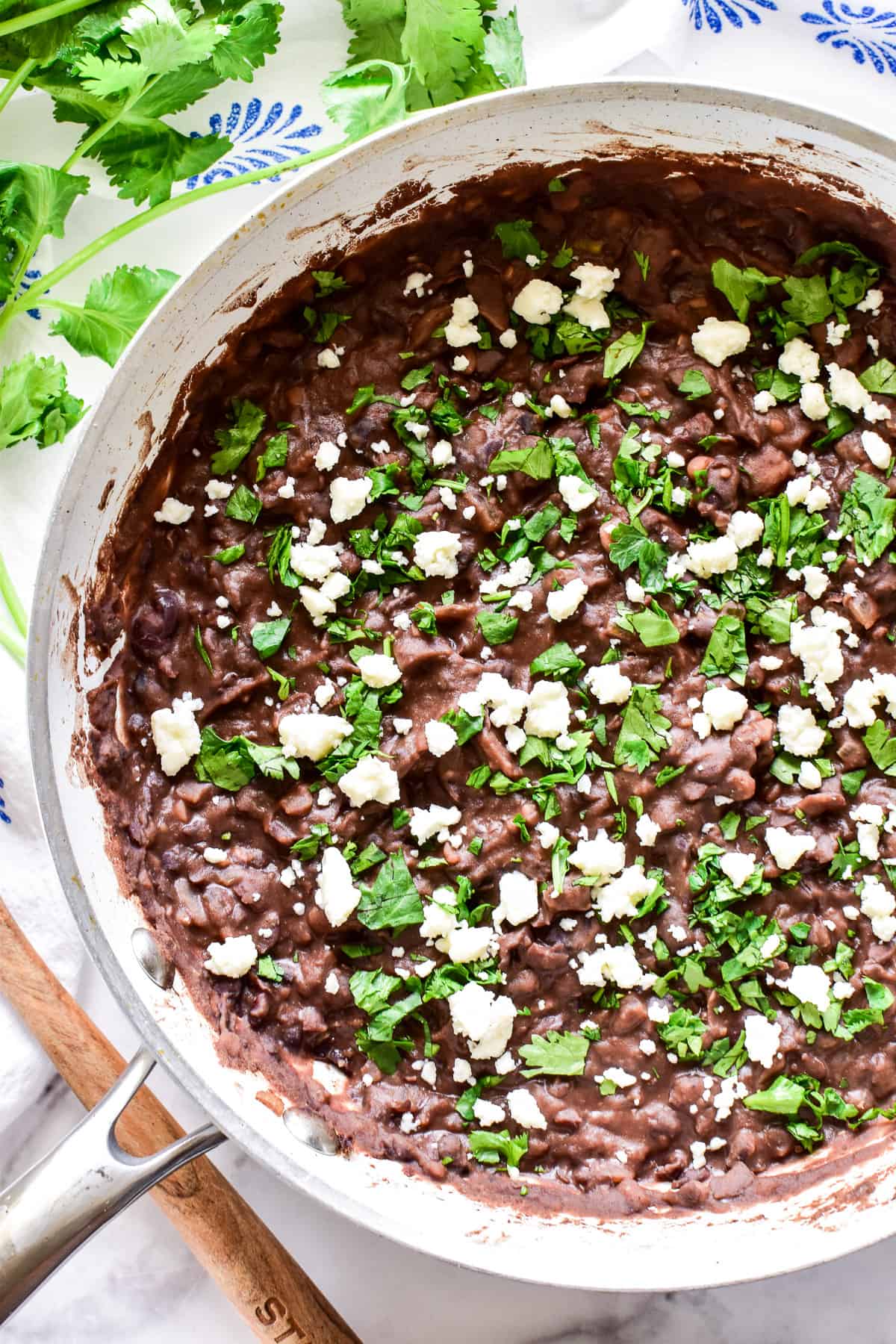 Overhead shot of Refried Black Beans in white skillet