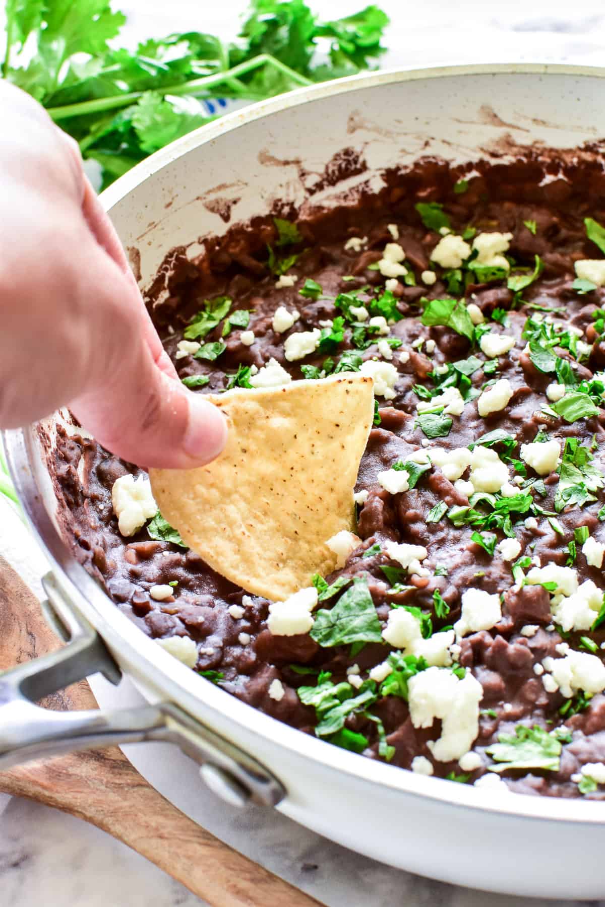 Dipping a chip into Refried Black Beans