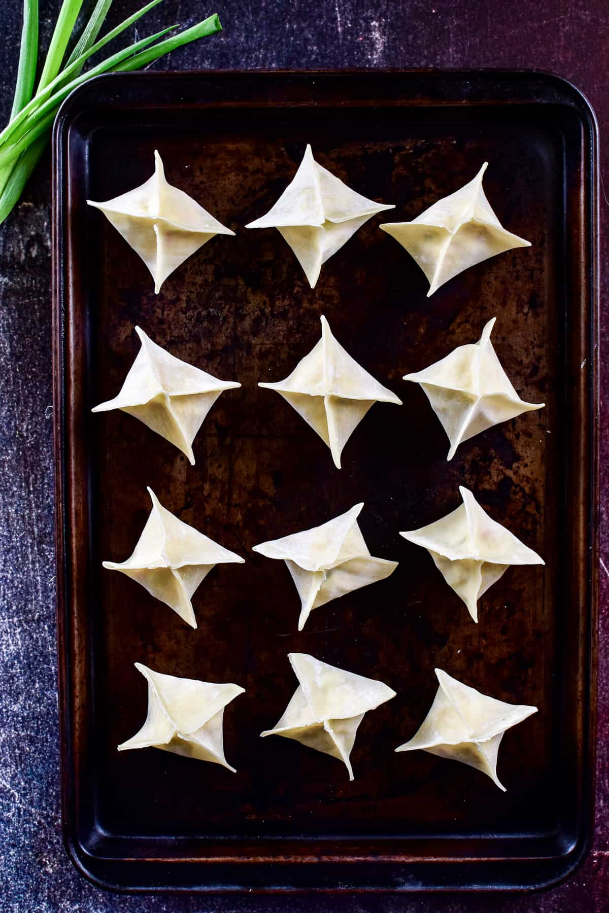 Crab Rangoon uncooked on baking sheet