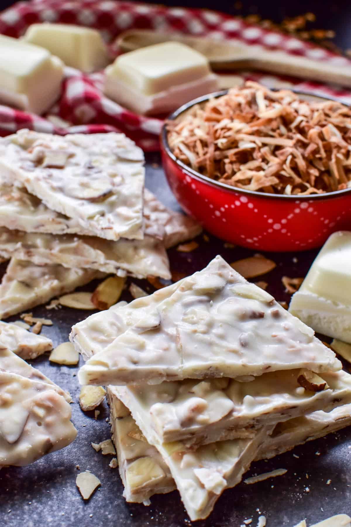 Toasted Coconut Bark stacked with a bowl of toasted coconut in the background