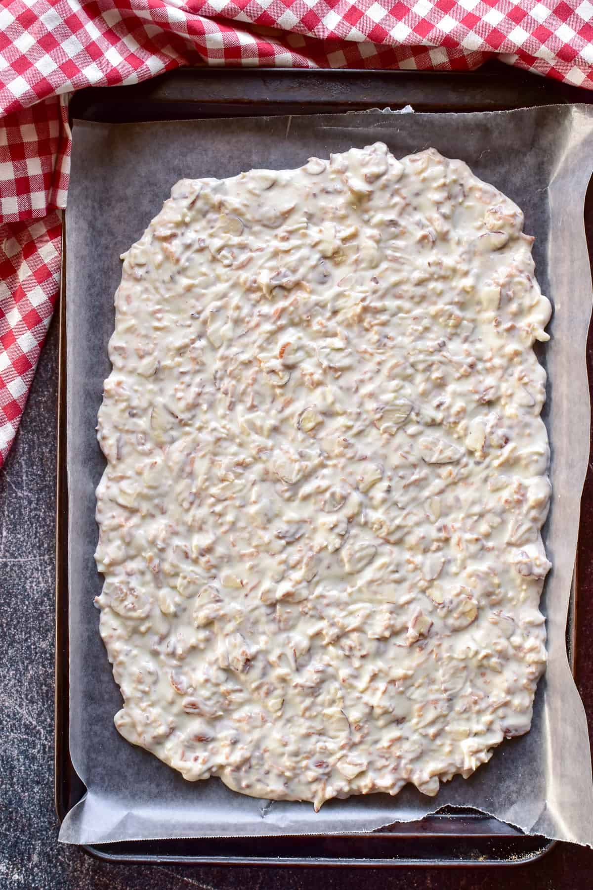 Toasted Coconut Bark spread out on pan lined with wax paper