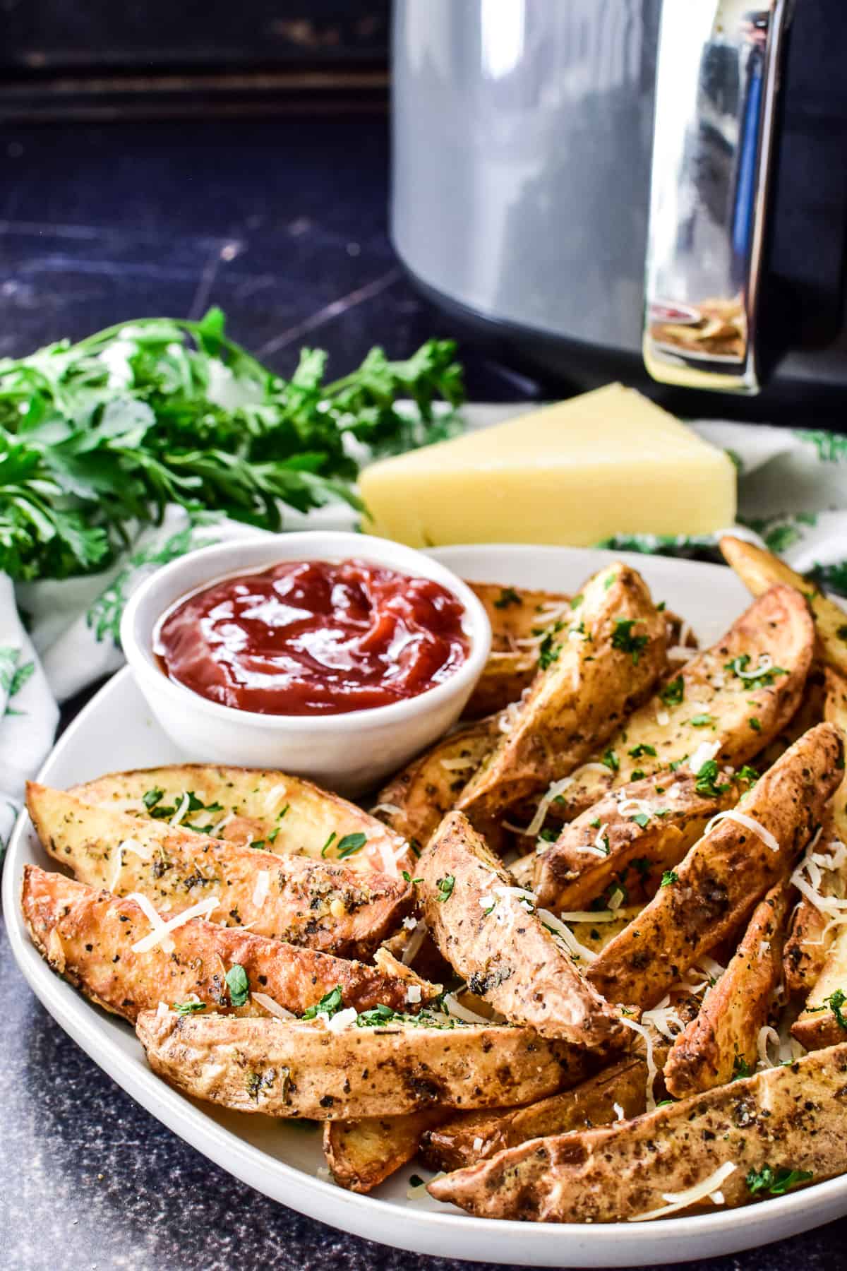 Potato Wedges on a plate with air fryer in the background