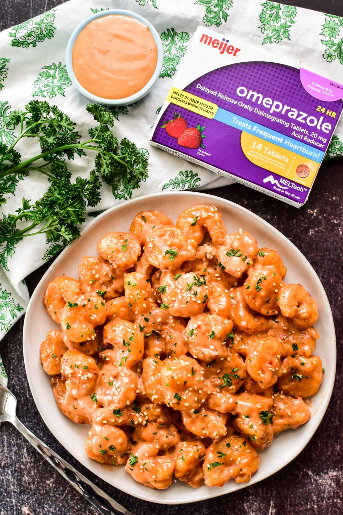 Overhead shot of Bang Bang Shrimp with a box of Meijer Omeprazole ODT
