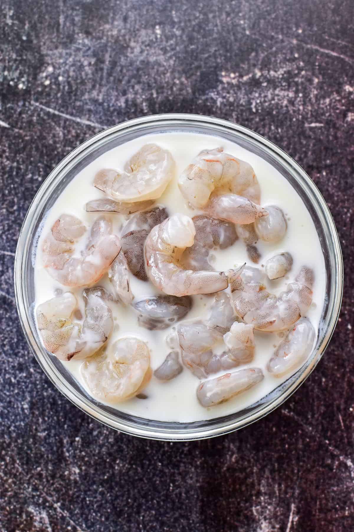 Raw shrimp soaking in buttermilk