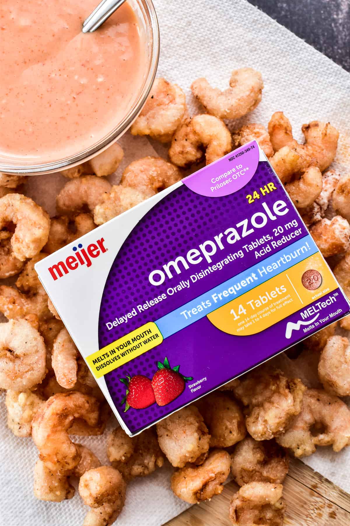 Close up of fried shrimp with a box of Meijer Omeprazole ODT