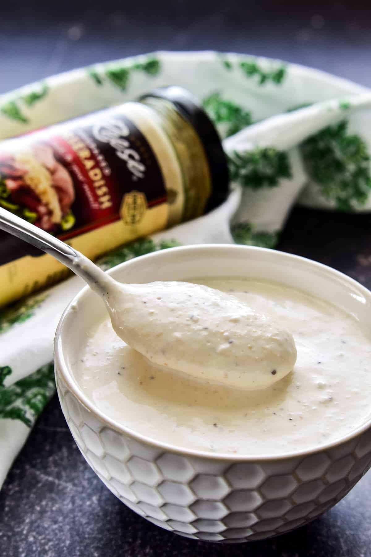 Horseradish Sauce in a small white bowl with a serving spoon