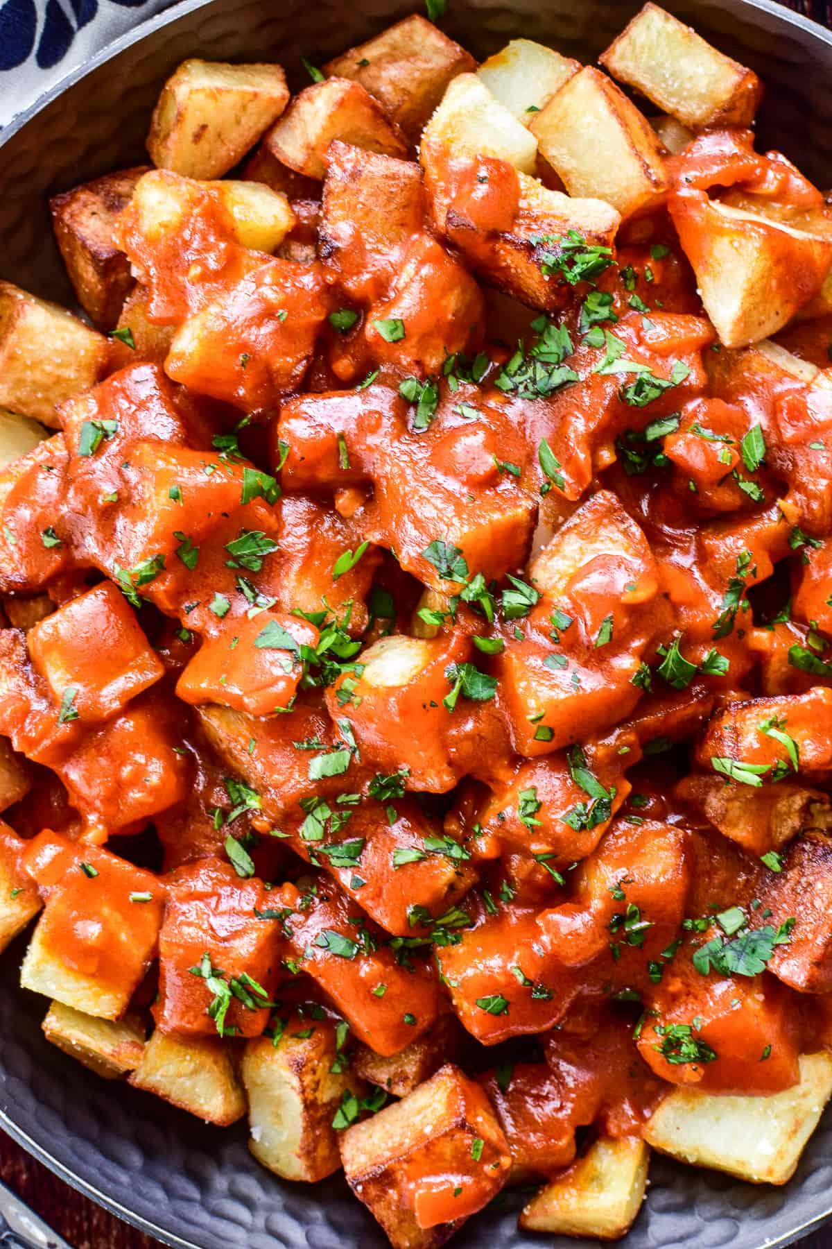 Close up of Patatas Bravas with minced parsley