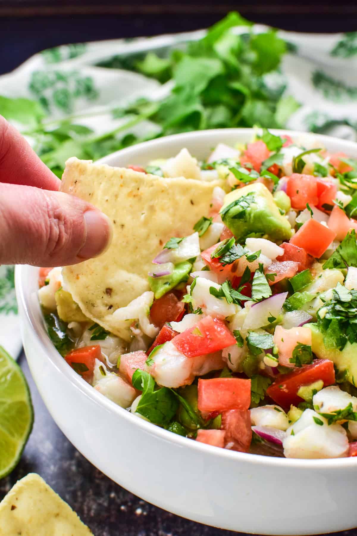 Tortilla chip being dipped into shrimp ceviche