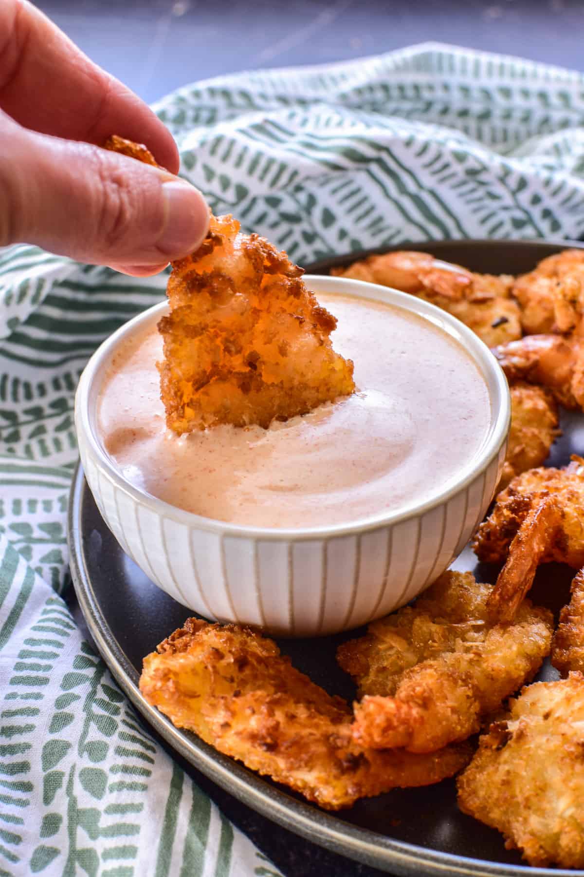 Coconut Shrimp being dipped into Yum Yum Sauce