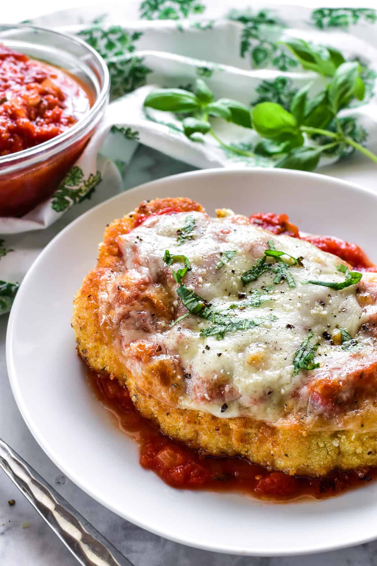 Cauliflower Parmesan on a white plate with a green & white napkin